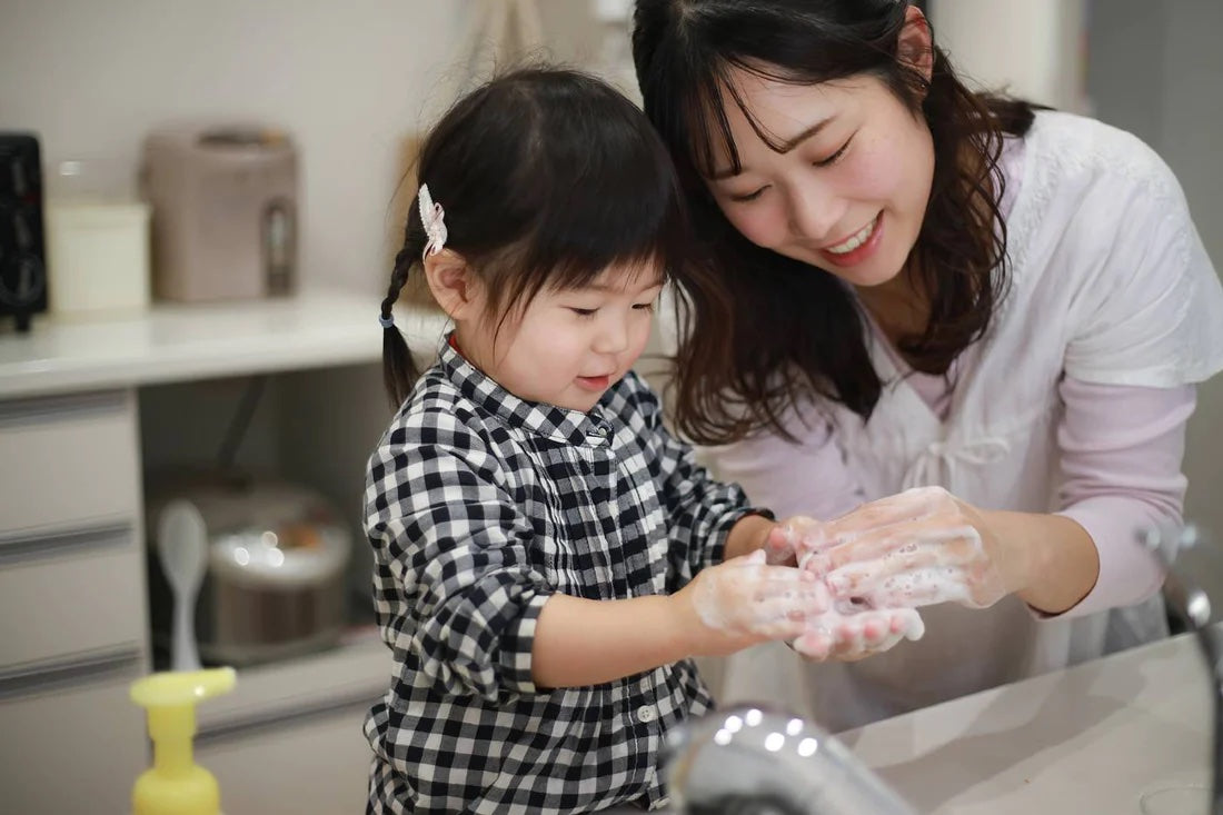 A mum and daughter wash their hands together