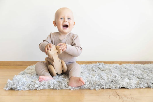 A baby plays with a safe toy