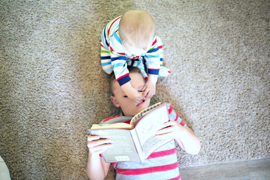 A baby pinches and pulls at his older brother