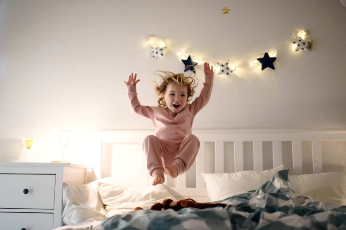 Toddler jumping on a bed