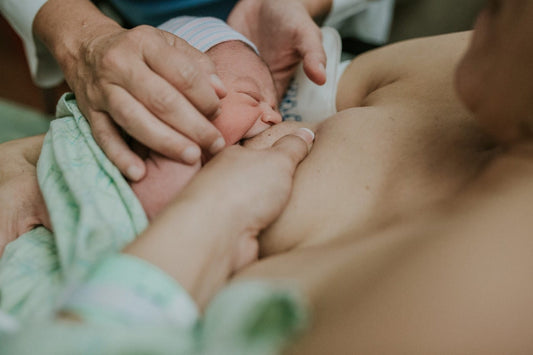 Newborn baby breastfeeding for the first time.