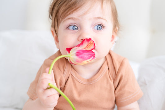flower and botanical baby names: baby holding flower