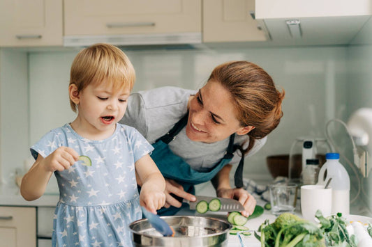 mom cutting food for toddler in kitchen