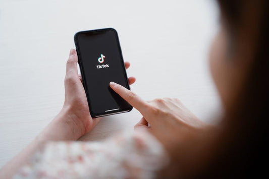 A woman looks at the TikTok app on her smartphone