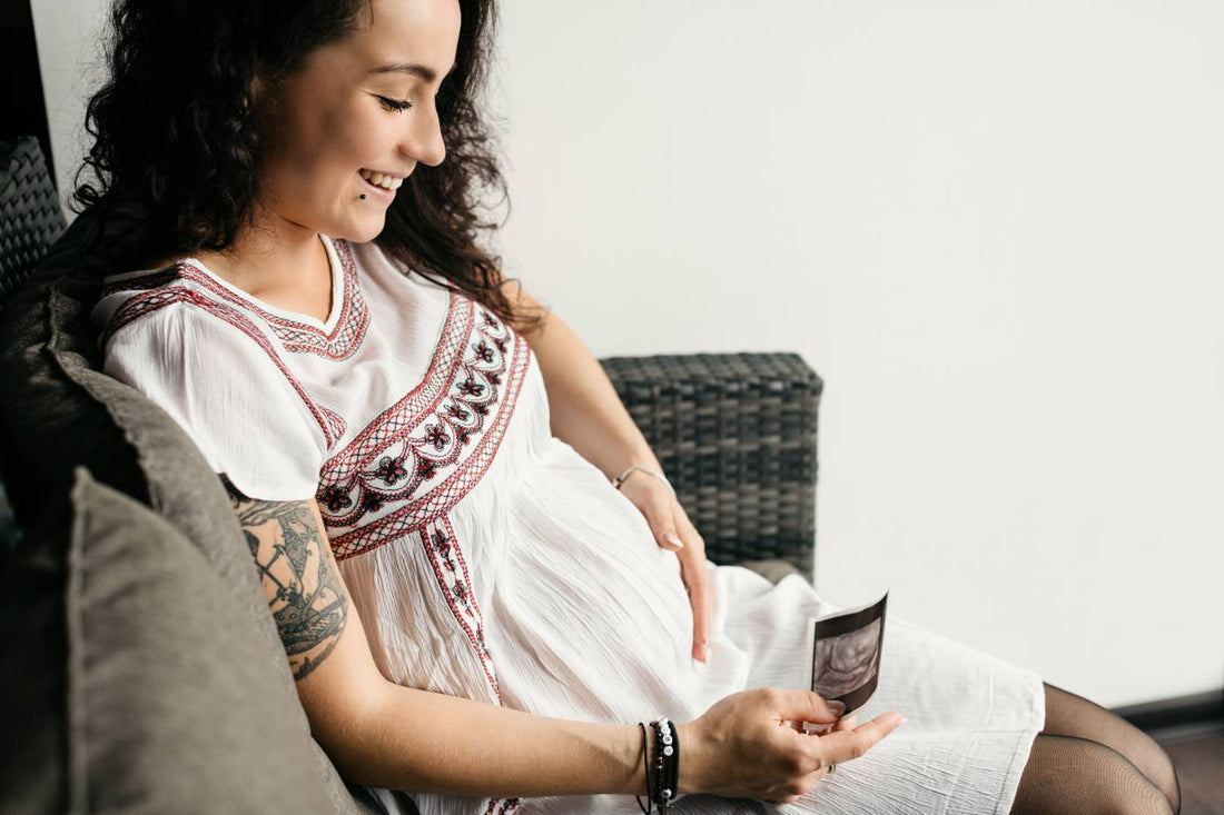 second trimeter symptoms: Pregnant woman looking at sonogram print out