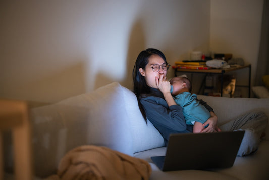 Tired mum holds newborn at night