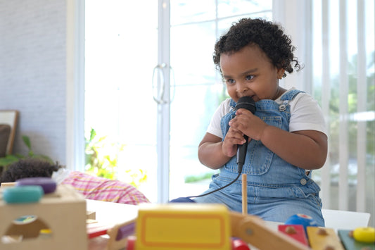 2-year-old girl talking into toy microphone
