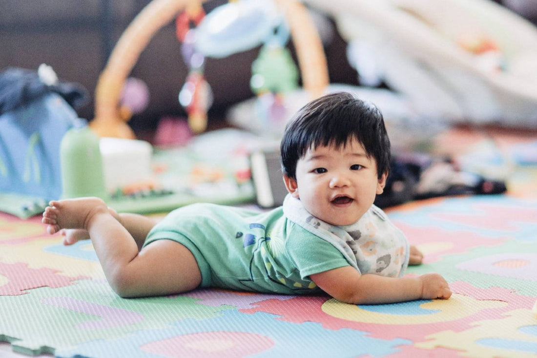 Baby boy doing tummy time on a play mat.