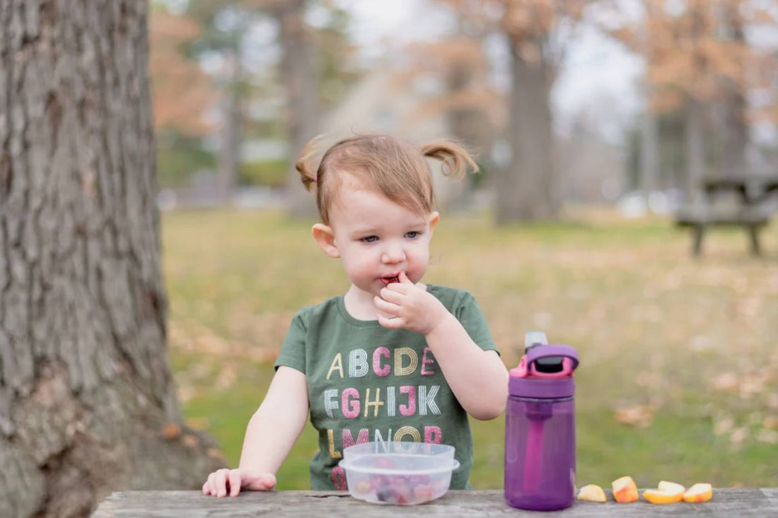 nappy bag snacks: toddler eating snacks in park